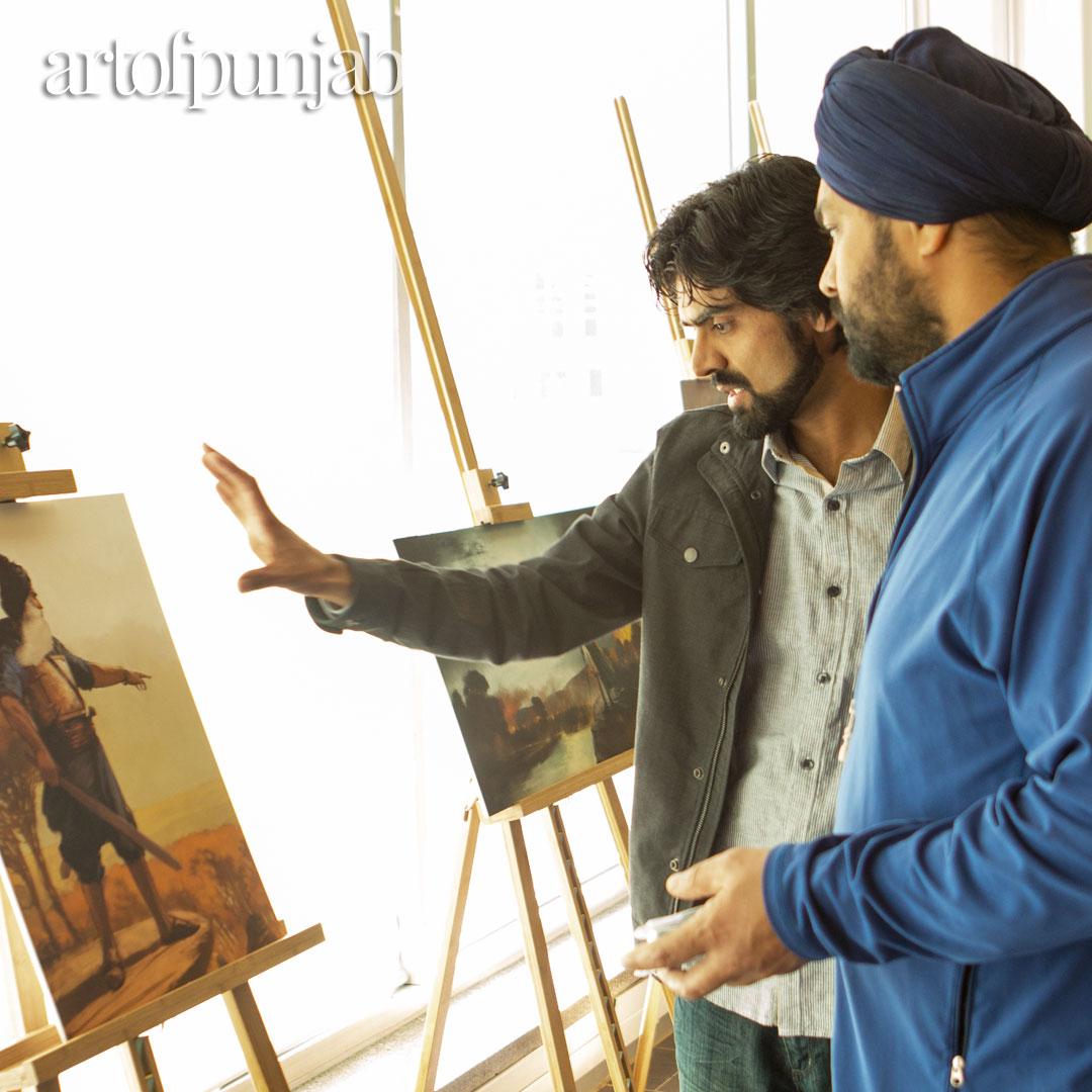 Photo of two men looking at a painting on an easel